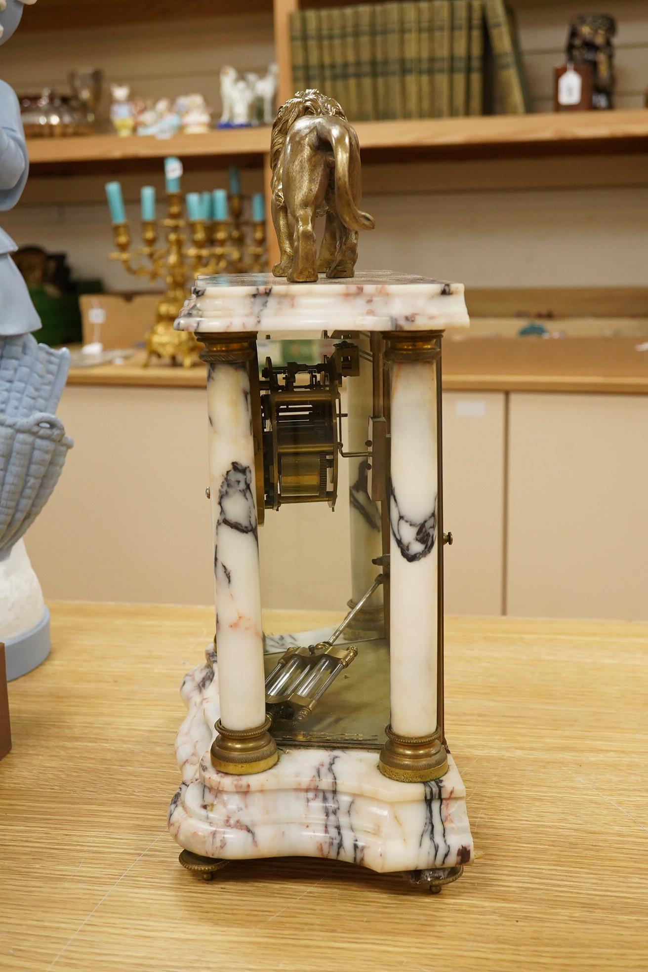 An early 20th century marble mantel clock with lion surmount, with pendulum, 39cm high